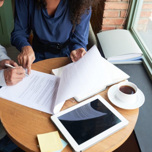 Businessman signing contact at the meeting in cafe